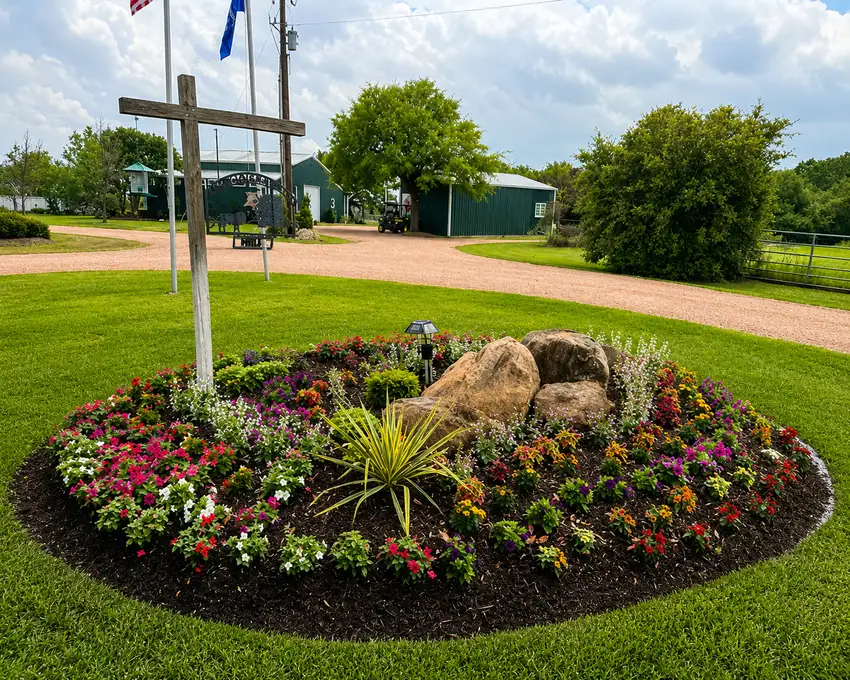 Circular color bed with boulders below a ranch cross — Ranch Services